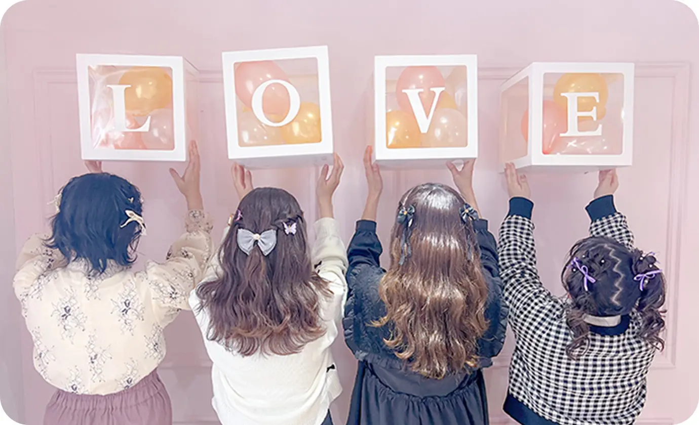 4人の女性がそれぞれ英文字を掲げて、LOVEの文字を作っている様子
