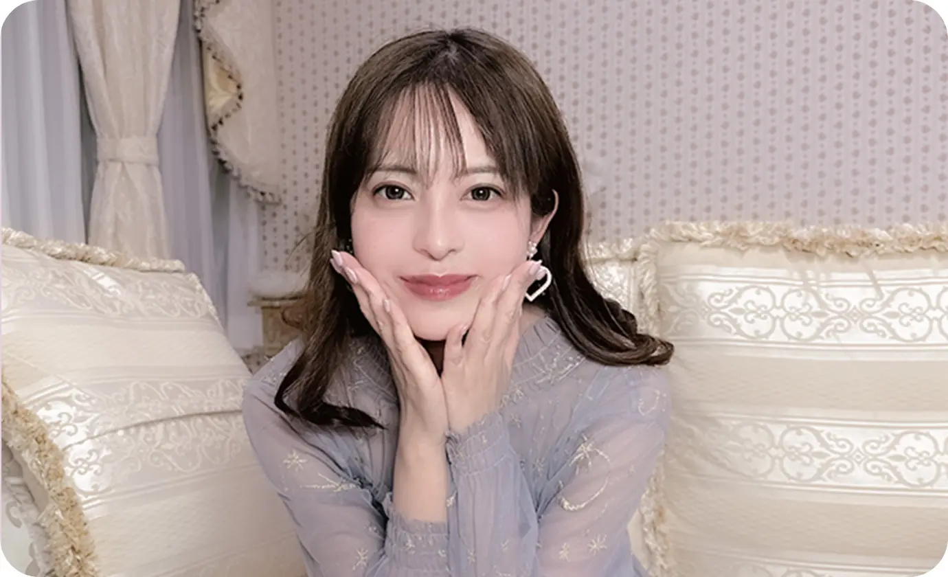 両手を顔に当てながら微笑む女性のポートレート
